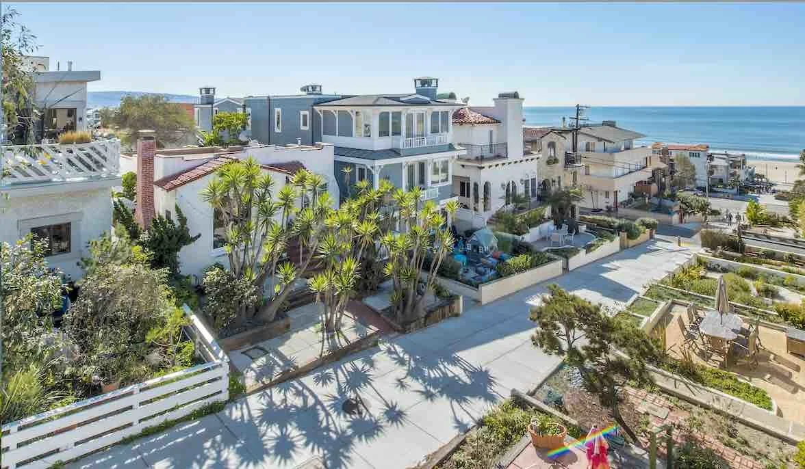 Coastal homes and palm-lined streets of Manhattan Beach with the Pacific Ocean in the distance